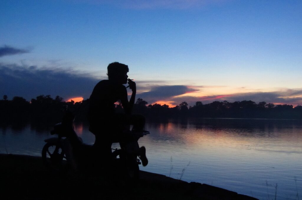 Using the back light to silhouette this motorbike driver at sunset. Sras Srong Lake, Siem Reap, Cambodia. 