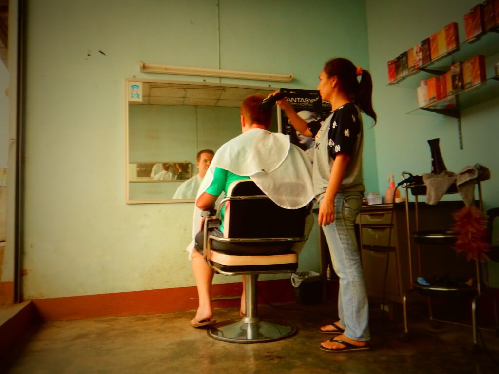 Mae Salong in Northern Thailand Stevo getting a haircut in a small roadside salon
