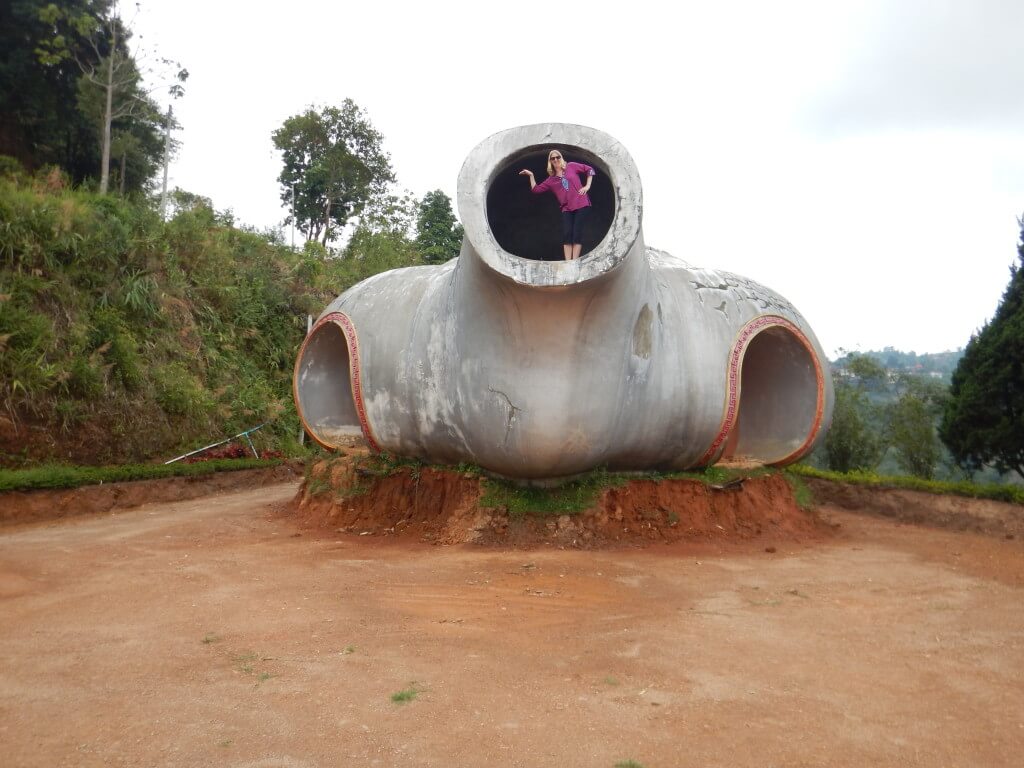 Mae Salong in Northern Thailand a woman is standing inside a giant teapot making a teapot shape with her body