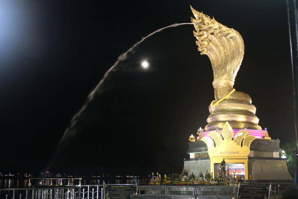 The Naga Monument in Nakhon Phanom, Thailand at night by Two Can Travel
