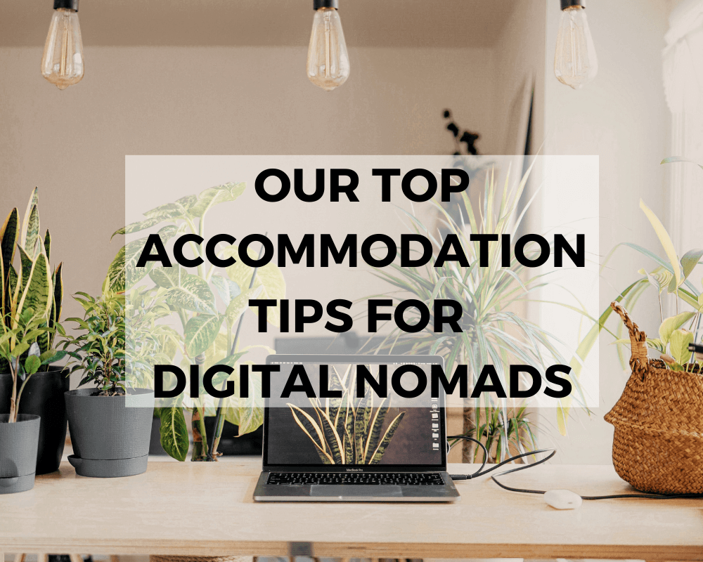 How to Become a Digital Nomad. Your Ultimate Guide to starting Digital Nomad life. Our Top Accommodation Tips for Digital Nomads. Picture of a laptop open on a desk with many plants sitting on the desk. Link is to a video about this topic. 