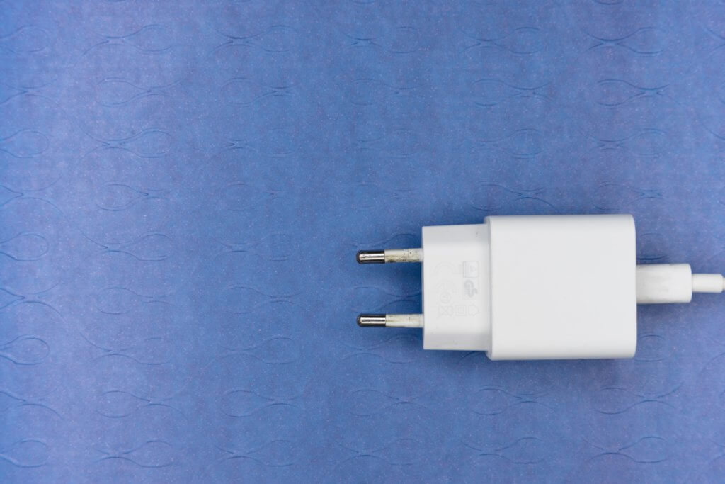How to Become a Digital Nomad. Your Ultimate Guide to starting Digital Nomad life. Image of a white plug sitting on a blue background. 