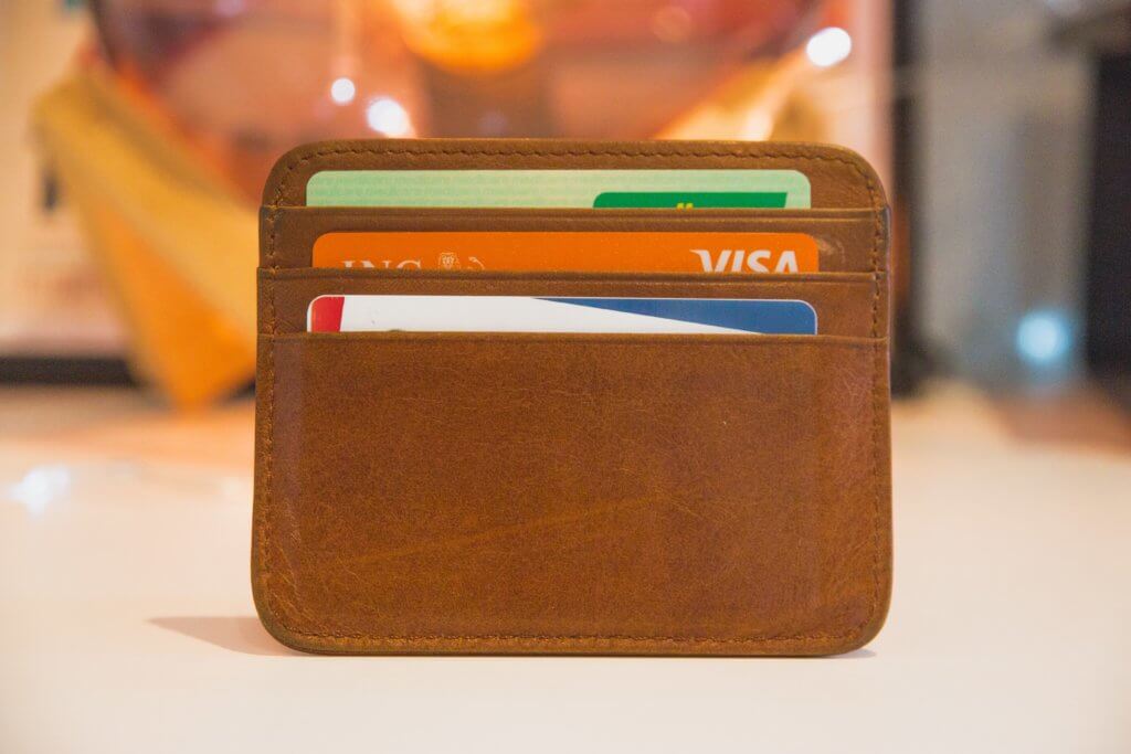 How to Become a Digital Nomad. Your Ultimate Guide to starting Digital Nomad life. Image of a wallet open with credit cards showing. 
