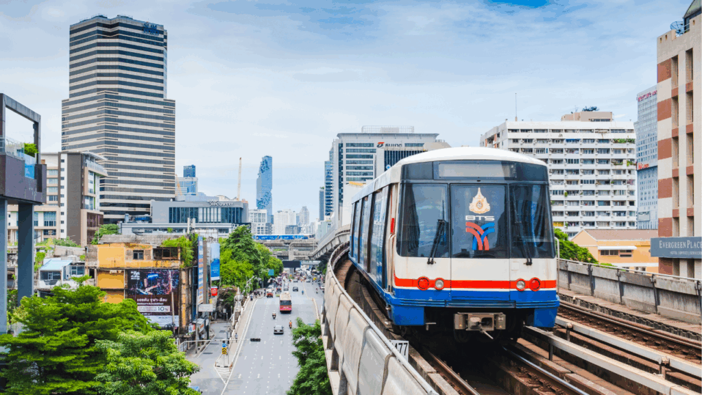 BTS skytrain on the right hand side riding past tall buildings in Bangkok